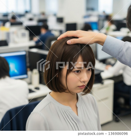 A male employee sexually harasses a young female employee by touching her head in the company office. 136986096