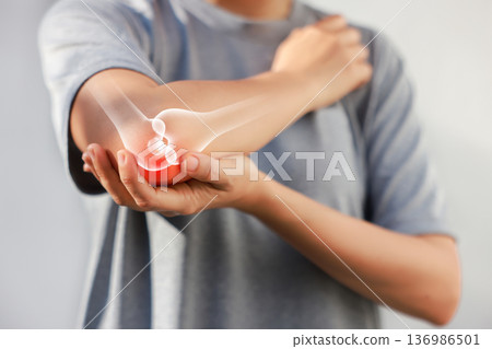 Asian woman suffering from elbow joint pain with red x-ray bone graphic overlay, female touching arm feeling ache from inflammation, arthritis, tendonitis or injury in garden, healthcare concept. Asian woman suffering from elbow joint pain with red x-ray bone graphic overlay, female touching arm feeling ache from inflammation, arthritis, tendonitis or injury in garden, healthcare concept. 136986501