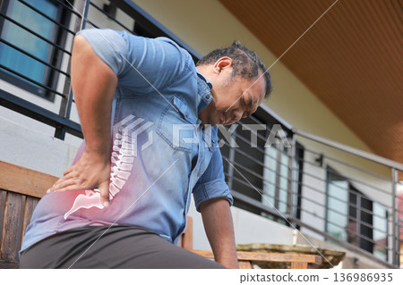 Mature Asian man suffering from back pain with red x-ray spine bone graphic overlay, male holding his lower back feeling ache from muscle strain, herniated disc or office syndrome. Mature Asian man suffering from back pain with red x-ray spine bone graphic overlay, male holding his lower back feeling ache from muscle strain, herniated disc or office syndrome. 136986935