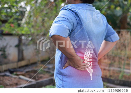 Mature Asian man suffering from back pain with red x-ray spine bone graphic overlay, male holding his lower back feeling ache from muscle strain, herniated disc or office syndrome. Mature Asian man suffering from back pain with red x-ray spine bone graphic overlay, male holding his lower back feeling ache from muscle strain, herniated disc or office syndrome. 136986936