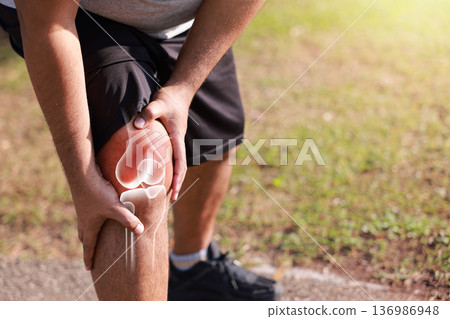 Man suffering from knee joint pain while running in park with red x-ray bone graphic overlay, male athlete touching leg feeling ache from sport injury, ligament tear or tendonitis. 136986948
