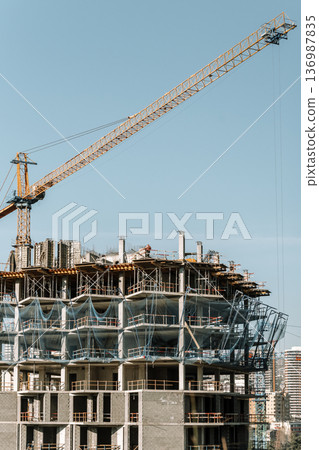 Construction of a building. Construction site with crane. Business, development, industry. 136987835
