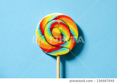 Swirl lollipop on a blue background colorful candy concept Swirl lollipop on a blue background colorful candy concept 136987848