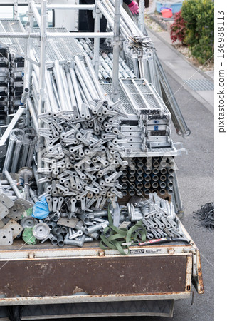 建築工人的車輛和鷹架材料正在準備搭建鷹架，用於外牆粉刷。 136988113