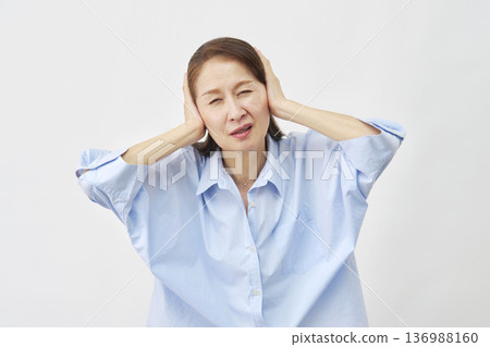 一位老婦人在白色背景下摀著耳朵 136988160