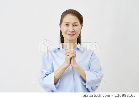 Elderly woman praying on white background 136988163