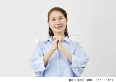 Elderly woman praying on white background 136988164