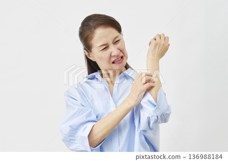 一位女士在白色背景上搔手臂 136988184