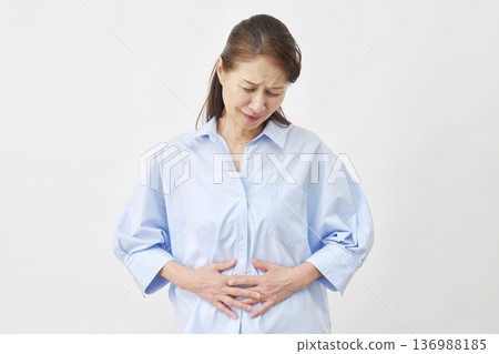 一位女士在白色背景下忍受胃痛。 136988185