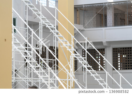 The steel used to construct the white scaffolding ladder is sturdy and long lasting. The steel used to construct the white scaffolding ladder is sturdy and long lasting. 136988582