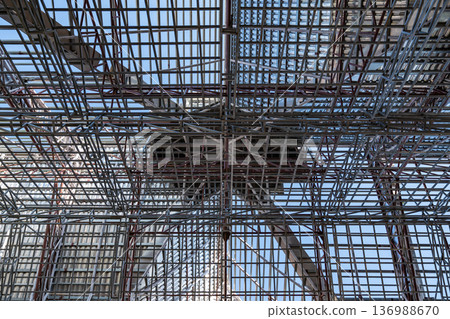 Uprisen angle photo shot of the huge steel roof frame structure detail under construction at the work site. 136988670