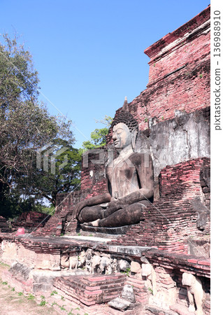 Ancient stone Buddha statue, Wat Sa Si temple, Sukhothai historical park. Picturesque scene with Buddha statuary, Sukhothai old city, Northern Thailand. Topic of vacation, travel, trip, cruise, tour Ancient stone Buddha statue, Wat Sa Si temple, Sukhothai historical park. Picturesque scene with Buddha statuary, Sukhothai old city, Northern Thailand. Topic of vacation, travel, trip, cruise, tour 136988910