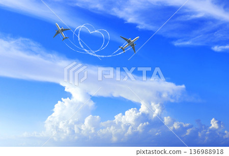 Horizontal background with aircraft on cloudy sky. Two airplane drawing a heart in sky. Jet flight route of aircraft in shape of a heart in blue sky. Topic of holiday, travel, trip abroad on vacation Horizontal background with aircraft on cloudy sky. Two airplane drawing a heart in sky. Jet flight route of aircraft in shape of a heart in blue sky. Topic of holiday, travel, trip abroad on vacation 136988918