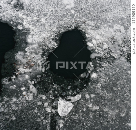 A hole in the frozen lake surface 136989150