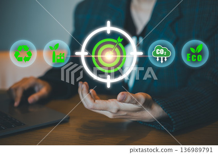Businessperson presenting eco-friendly icons and target symbol, representing sustainable business practices and environmental goals. 136989791
