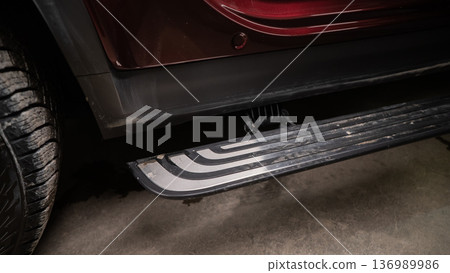 Folding step of a red modern car.  136989986