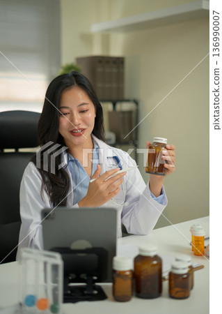 Doctor providing telemedicine consultation, recommending vitamin intake to a patient through online video call on tablet in a modern clinic. Doctor providing telemedicine consultation, recommending vitamin intake to a patient through online video call on tablet in a modern clinic. 136990007