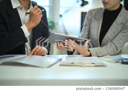 Teamwork meeting with tablet and business people in office workplace, closeup shot Teamwork meeting with tablet and business people in office workplace, closeup shot 136990047