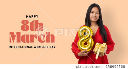 A young woman holds a gold number 8 and a gift, smiling proudly A young woman holds a gold number 8 and a gift, smiling proudly 136990566