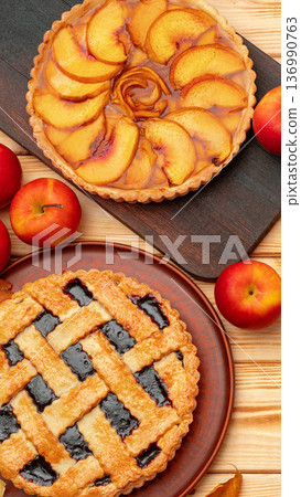 Delicious fruit pies on wooden table with fresh apples around them 136990763