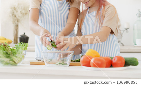 Cooking together in the kitchen with fresh vegetables at home during the day Cooking together in the kitchen with fresh vegetables at home during the day 136990853