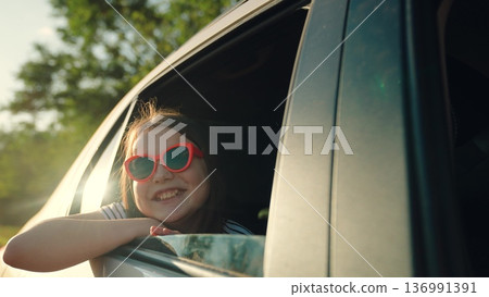 Happy girl waving from car, happy female face, summer trip sea, vacation picnic party, vacation fun, people sunglasses, travel lifestyle concept, happy travel childhood, adventure seeking kid, young 136991391