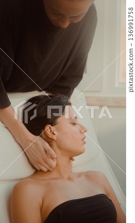 Professional delivers calming seated neck treatment session Professional delivers calming seated neck treatment session 136991758