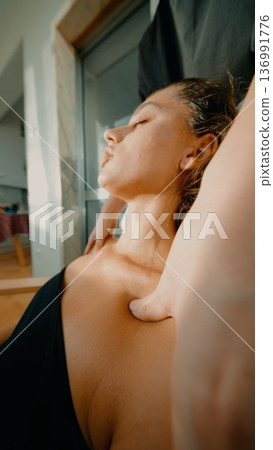 Woman enjoying calming neck massage with soft natural lighting Woman enjoying calming neck massage with soft natural lighting 136991776