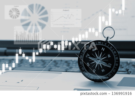電腦上放置著指南針和股票圖表。 136991916