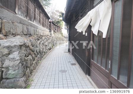 一條僻靜的小巷，兩旁是石牆和木屋。 136991976