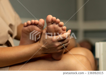 Close-up of mother holding child's foot for massage 136992015