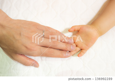 Parent's hand holding baby's hand Parent's hand holding baby's hand 136992289