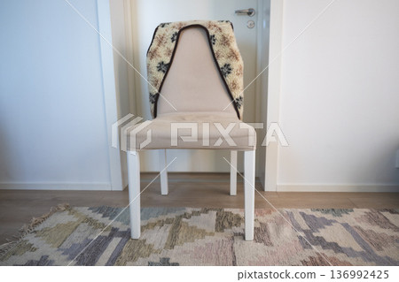Minimalist upholstered chair with cozy blanket in Scandinavian home interior 136992425