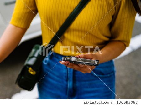 A woman holds a smartphone. Photo courtesy of Kansai International Airport (KIX) 136993063