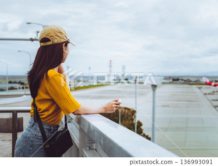 A woman looking at the scenery at the airport. Photo courtesy of Kansai International Airport (KIX). 136993091