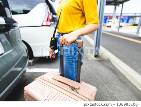 A woman carrying luggage at the airport. Photo courtesy of Kansai International Airport (KIX) 136993100
