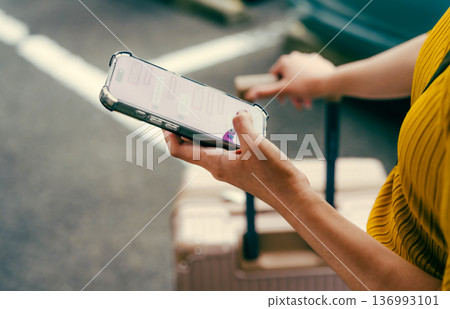 A woman using a smartphone at the airport. Photo courtesy of Kansai International Airport (KIX) 136993101