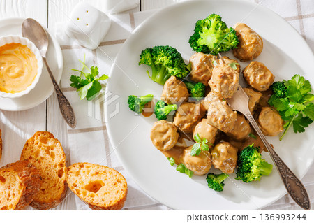Belgian meatballs in creamy gravy with broccoli and bread 136993244