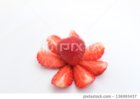 Strawberries cut into a flower shape on a plate on a white background 136993437