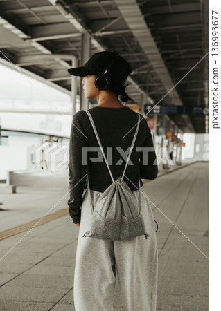 A woman listening to music at the station. Photo courtesy of Kansai International Airport (KIX) 136993677