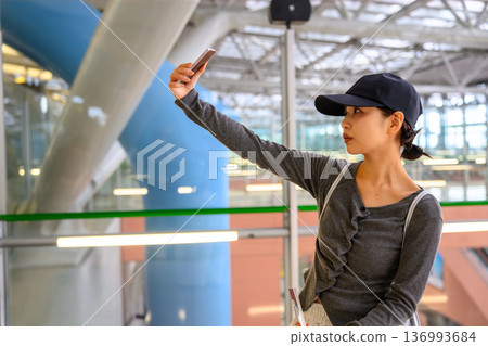 A woman taking a selfie at the airport. Photo courtesy of Kansai International Airport (KIX). A woman taking a selfie at the airport. Photo courtesy of Kansai International Airport (KIX). 136993684