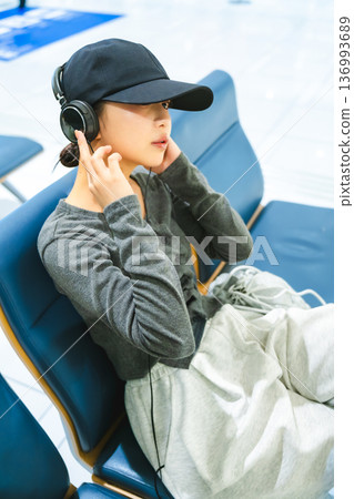 一位女士戴著耳機聽音樂。照片由關西國際機場（KIX）提供。 136993689