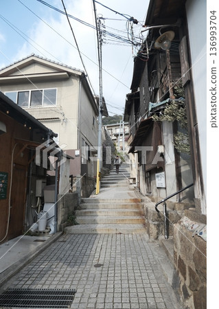 A hilly alley with stone steps and old townscape A hilly alley with stone steps and old townscape 136993704