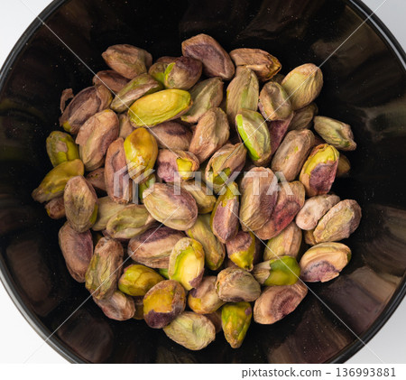 Fried salt pistachio nuts isolated. Baked pistachios pile, roasted green pistache fruits on white Fried salt pistachio nuts isolated. Baked pistachios pile, roasted green pistache fruits on white 136993881