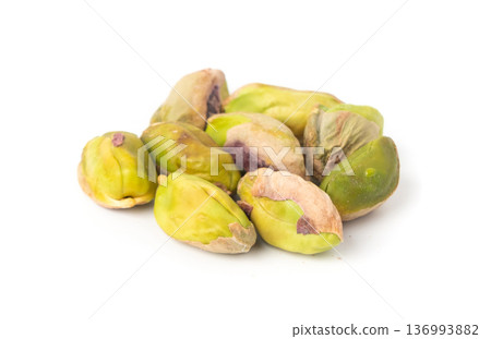 Fried salt pistachio nuts isolated. Baked pistachios pile, roasted green pistache fruits on white 136993882