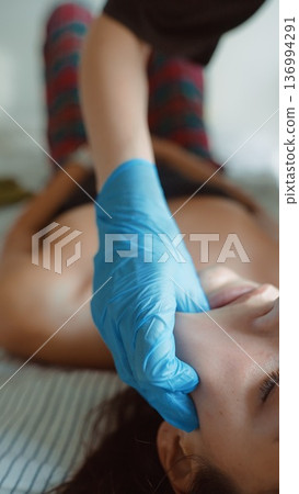 Comfortable woman receiving routine nasal testing from caregiver at home Comfortable woman receiving routine nasal testing from caregiver at home 136994291