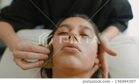 Gentle facial massage focusing on skin health and relaxation Gentle facial massage focusing on skin health and relaxation 136994307