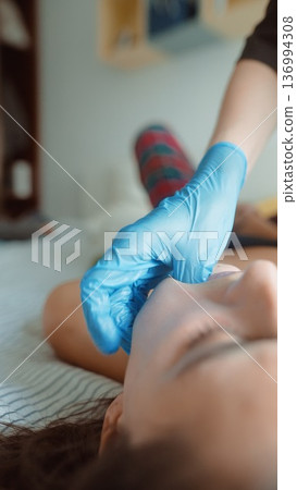 Aesthetic nurse preparing female patient for facial filler 136994308