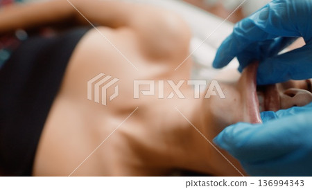 Dermatologist administering chest filler on female patient Dermatologist administering chest filler on female patient 136994343