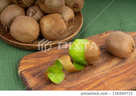 Kiwi fruit peel on wood cutting board Kiwi fruit peel on wood cutting board 136994715